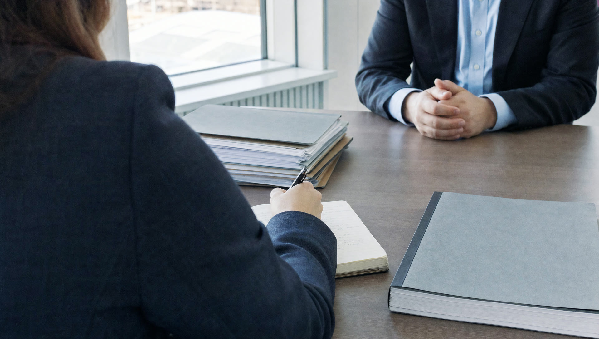 Auditor maakt aantekeningen tijdens een gesprek